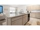 Modern kitchen featuring an island with granite countertops, a black sink, and lots of storage space at 7571 Sw 64Th Street Rd, Ocala, FL 34474