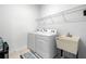 Functional laundry room equipped with a washer, dryer, and utility sink for added convenience at 7571 Sw 64Th Street Rd, Ocala, FL 34474