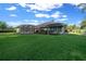 Generous backyard with a screened-in patio for outdoor dining, complemented by a green lawn and privacy shrubs at 811 Se 49Th Ave, Ocala, FL 34471