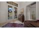 This foyer offers a decorative rug, tile flooring, a wooden cabinet, and elegant double doors leading outside at 811 Se 49Th Ave, Ocala, FL 34471
