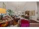 The living room is furnished with leather sofas, a chandelier, and a large window with plantation shutters at 811 Se 49Th Ave, Ocala, FL 34471
