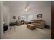 Bright living room featuring neutral carpet, a ceiling fan, and comfortable seating arrangements at 811 Se 49Th Ave, Ocala, FL 34471