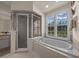 Bathtub in the main bathroom with tile surround and shower with glass door at 811 Se 49Th Ave, Ocala, FL 34471