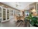 Bright sunroom features a ceiling fan, glass table, and wicker chairs for relaxed, comfortable living at 811 Se 49Th Ave, Ocala, FL 34471