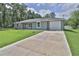 Single-story home with a gray exterior, attached garage, and a long concrete driveway at 838 Nw 124Th Street, Citra, FL 32113