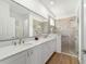 Bright bathroom features double sinks, modern vanity, large mirror, and glass enclosed shower at 8693 Sw 76Th Ln, Ocala, FL 34481
