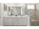 Bright bathroom features double sinks, modern vanity, large mirror, and glass enclosed shower at 8693 Sw 76Th Ln, Ocala, FL 34481