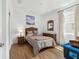 Cozy bedroom with wicker furniture, comfortable bed, and wood-look flooring at 8693 Sw 76Th Ln, Ocala, FL 34481