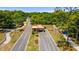 Aerial view of community entry gate featuring mature trees and professional landscaping with colorful flowers at 8693 Sw 76Th Ln, Ocala, FL 34481