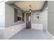 View of a covered front porch with decorative hanging light fixture and textured walls at 8693 Sw 76Th Ln, Ocala, FL 34481