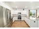 Modern kitchen with white cabinets, stainless steel appliances, and hardwood floors at 8693 Sw 76Th Ln, Ocala, FL 34481