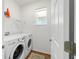 Well-lit laundry room equipped with washer, dryer, shelving, window, and door at 8693 Sw 76Th Ln, Ocala, FL 34481