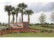 Community entrance sign featuring 'On Top of the World' with vibrant floral landscaping at 8747 Sw 98Th Street Rd # F, Ocala, FL 34481