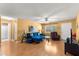 Spacious living room with hardwood floors, ceiling fan, and a comfortable blue sectional couch at 8747 Sw 98Th Street Rd # F, Ocala, FL 34481
