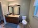 Functional bathroom with a vanity, neutral tile flooring, and a well-lit mirror for everyday convenience at 8951 Sw 202Nd Avenue Rd, Dunnellon, FL 34431