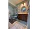 Well-lit bathroom featuring a blue-tiled shower/tub combination, with a classic vanity and mirror at 8951 Sw 202Nd Avenue Rd, Dunnellon, FL 34431