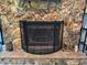 Close-up of the stone fireplace, complete with a protective screen and hearth at 8951 Sw 202Nd Avenue Rd, Dunnellon, FL 34431