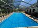 A sparkling in-ground swimming pool enclosed by a screened enclosure at 8951 Sw 202Nd Avenue Rd, Dunnellon, FL 34431