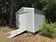 This is an image of a utility shed with a ramp on a property with some surrounding trees at 8951 Sw 202Nd Avenue Rd, Dunnellon, FL 34431