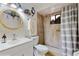 Charming bathroom featuring a modern vanity, stylish mirror, and tiled shower with a striped shower curtain at 9050 Sw 101St Ln, Ocala, FL 34481