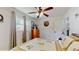 Bedroom with a patterned comforter, a ceiling fan, and a dresser near a window for natural light and space at 9050 Sw 101St Ln, Ocala, FL 34481