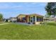 This charming yellow home has brick accents, a lovely front porch, and a covered parking area, surrounded by a lush green lawn at 9050 Sw 101St Ln, Ocala, FL 34481