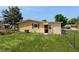 The yellow house has a well-maintained lawn, a window with a red trim and a chain link fence at 9050 Sw 101St Ln, Ocala, FL 34481