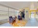 The covered patio features comfortable seating, a glass table, and a bright orange rug that complements the yellow siding at 9050 Sw 101St Ln, Ocala, FL 34481