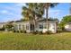 Lovely backyard featuring a screened lanai, lush lawn, neatly trimmed shrubs and mature palms at 9452 Sw 93Rd Loop, Ocala, FL 34481