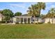 The backyard offers a serene view with lush green grass, palms, and a screened lanai at 9452 Sw 93Rd Loop, Ocala, FL 34481