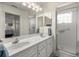 Bathroom features a double sink vanity with a marble countertop and a glass-enclosed shower at 9452 Sw 93Rd Loop, Ocala, FL 34481