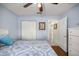 Light blue bedroom features hardwood floors, a closet, and a queen size bed with lots of natural light at 9452 Sw 93Rd Loop, Ocala, FL 34481