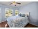 Light blue bedroom with hardwood floors features a queen bed with matching curtains and a ceiling fan at 9452 Sw 93Rd Loop, Ocala, FL 34481