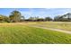 Picturesque view of community grounds featuring lush green grass, trees, and walking path at 9452 Sw 93Rd Loop, Ocala, FL 34481