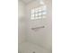 Modern walk-in shower features a glass block window, white tile, and silver hardware at 9452 Sw 93Rd Loop, Ocala, FL 34481