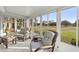 Relaxing sunroom with a view of the golf course features wicker furniture and lots of natural light at 9452 Sw 93Rd Loop, Ocala, FL 34481