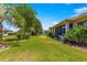 Lush green backyard with palm trees and well-maintained lawn, perfect for outdoor activities at 9773 Sw 90Th St, Ocala, FL 34481
