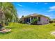 Well-maintained backyard featuring lush green grass, tropical landscaping, and a view of the home's exterior at 9773 Sw 90Th St, Ocala, FL 34481