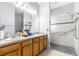 Updated bathroom with double sinks, oak cabinets, a spacious walk-in shower with grab bars and glass door at 9773 Sw 90Th St, Ocala, FL 34481
