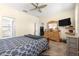Spacious bedroom featuring a large bed, wooden dresser, and a wall-mounted TV for entertainment at 9773 Sw 90Th St, Ocala, FL 34481