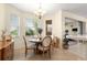 Cozy dining area with a round wood table, chandelier, and natural light from large windows at 9773 Sw 90Th St, Ocala, FL 34481