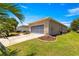 Garage view showcases manicured landscaping and an attached screened garage door at 9773 Sw 90Th St, Ocala, FL 34481