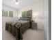Bright bedroom with neutral carpet and a large window offering a serene outdoor view at 10668 Sw 85Th Ter, Ocala, FL 34481