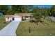 Inviting single-story home with an attached two-car garage, well-manicured lawn, and mature palm trees at 10668 Sw 85Th Ter, Ocala, FL 34481
