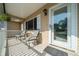 Inviting front porch with tiled flooring, white railing, and a cozy seating area at 10668 Sw 85Th Ter, Ocala, FL 34481