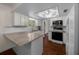 Well-lit kitchen featuring granite countertops, white cabinets, and stainless steel appliances at 10668 Sw 85Th Ter, Ocala, FL 34481