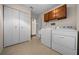 Laundry room features white washer, dryer, cabinet, and built in storage at 10668 Sw 85Th Ter, Ocala, FL 34481