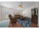 Bright living room with a ceiling fan, plush furniture, and a decorative front door at 10668 Sw 85Th Ter, Ocala, FL 34481