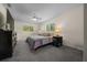 Comfortable main bedroom features a ceiling fan, two large windows, and plush carpeting at 10668 Sw 85Th Ter, Ocala, FL 34481