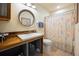 Bright bathroom featuring a rustic wood vanity and decorative shower curtain at 1114 Hickory Rd, Ocala, FL 34472